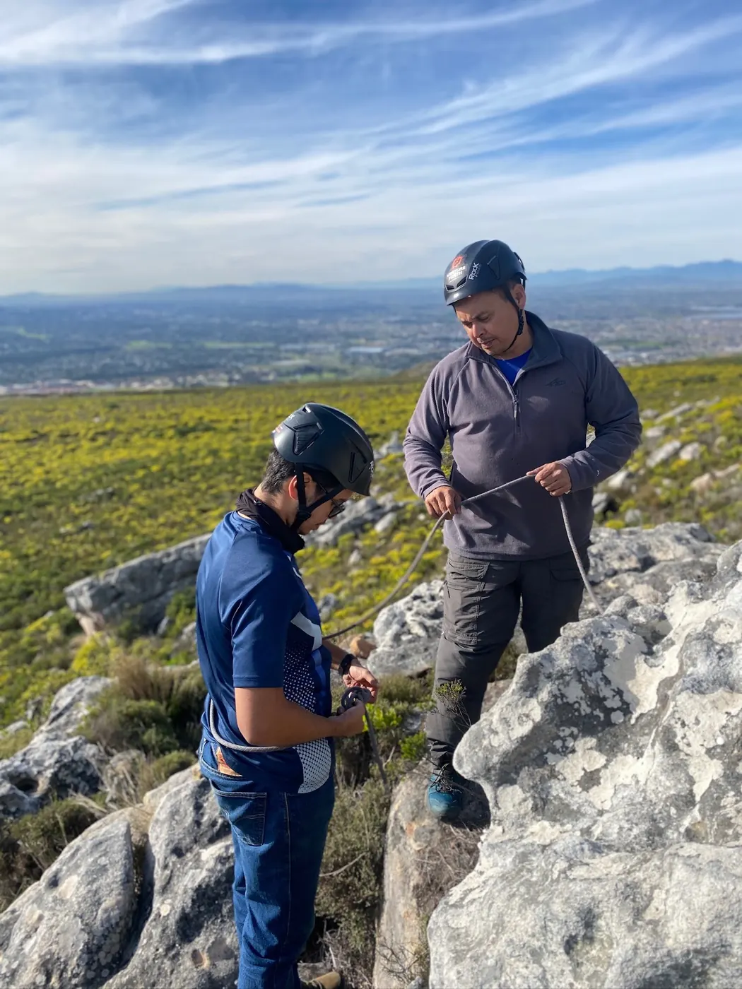 Two practitioners working with rope systems in mountain terrain